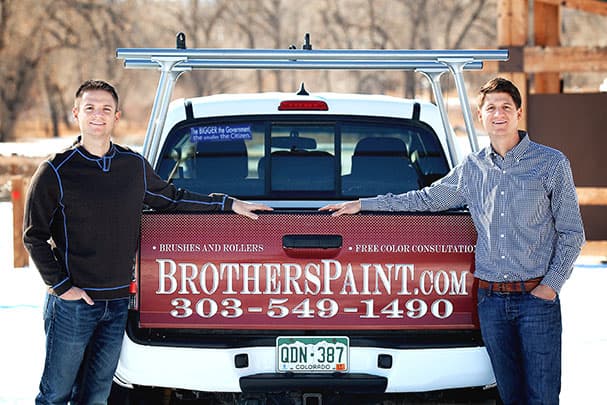 Jeremiah and Luke, the owners of BrothersPaint.com, at the tailgate of their branded pickup truck
